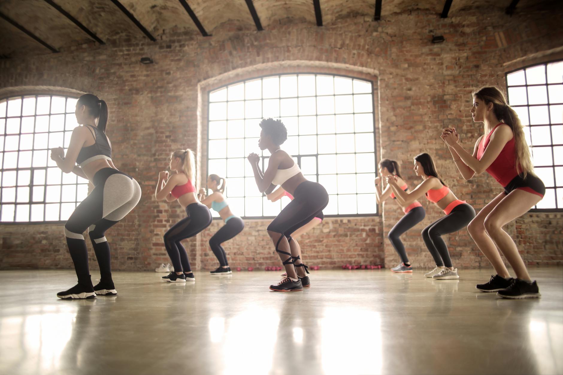 Zumba a zdrowe płuca: ćwiczenia oddechowe i tempo treningu przy astmie i alergiach Kobiety ćwiczące zumbę w grupie w industrialnym studio fitness